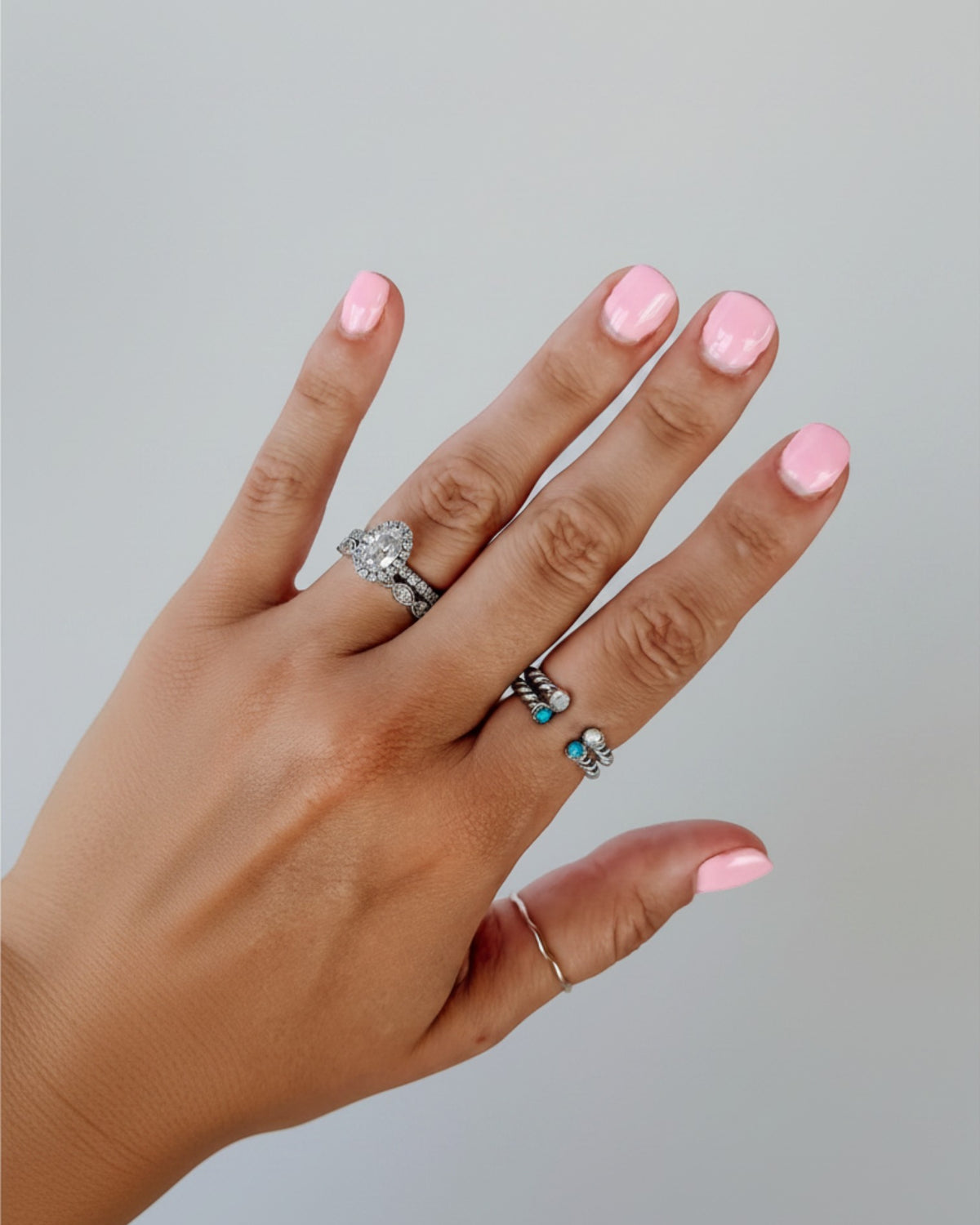 Wooten & Co. Nazareth sterling silver twist ring with mother of pearl stones worn on a finger with pink nail polish.
