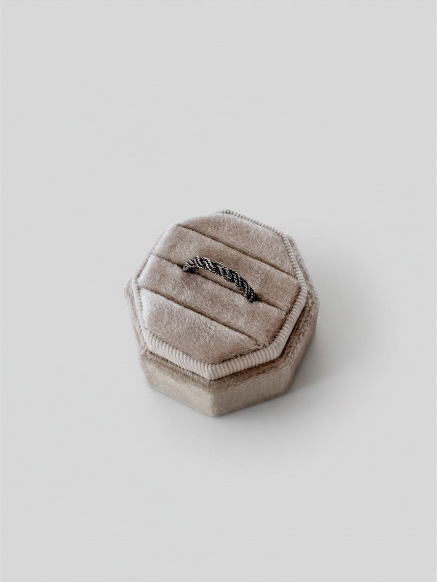 Wooten & Co. Kennard sterling silver twist ring displayed in a beige velvet hexagonal ring box