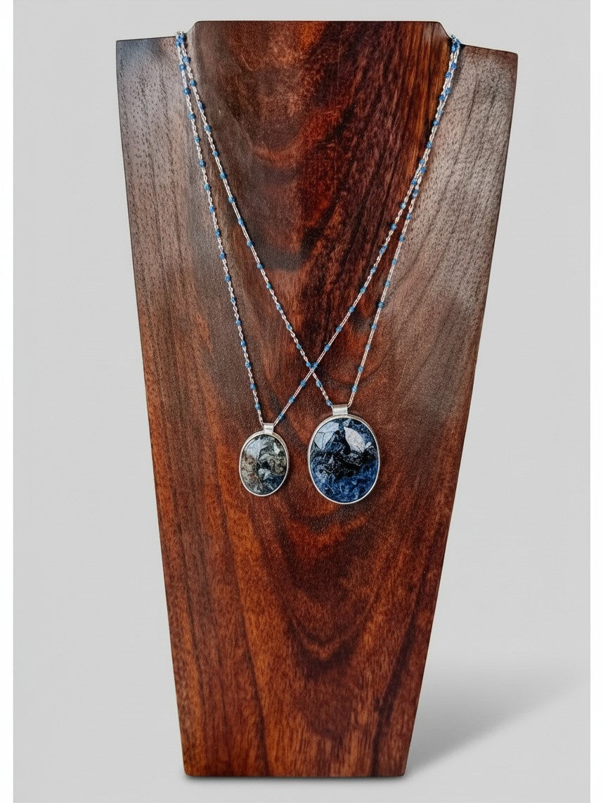 Wooten & Co. Blanco Blue Pietersite necklace featuring sterling silver chains with blue enamel beads on a wood display.