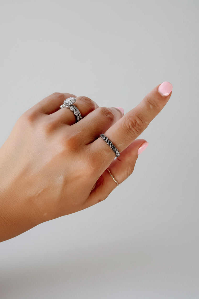Wooten & Co. Kennard sterling silver twist ring worn on a finger, showcasing a sculptural intertwined band design.