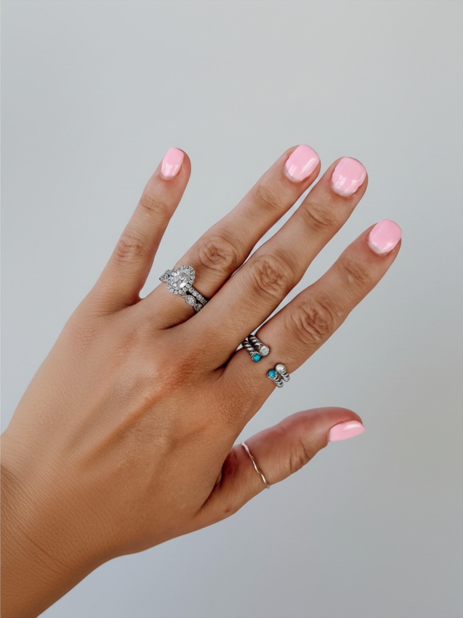 Wooten & Co. Nazareth sterling silver twist ring with mother of pearl stones worn on a finger with pink nail polish.