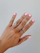 Wooten & Co. Nazareth sterling silver twist ring with mother of pearl stones worn on a finger with pink nail polish.