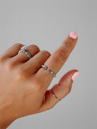 Wooten & Co. Nazareth turquoise twist ring in sterling silver with an adjustable open band design on a finger.