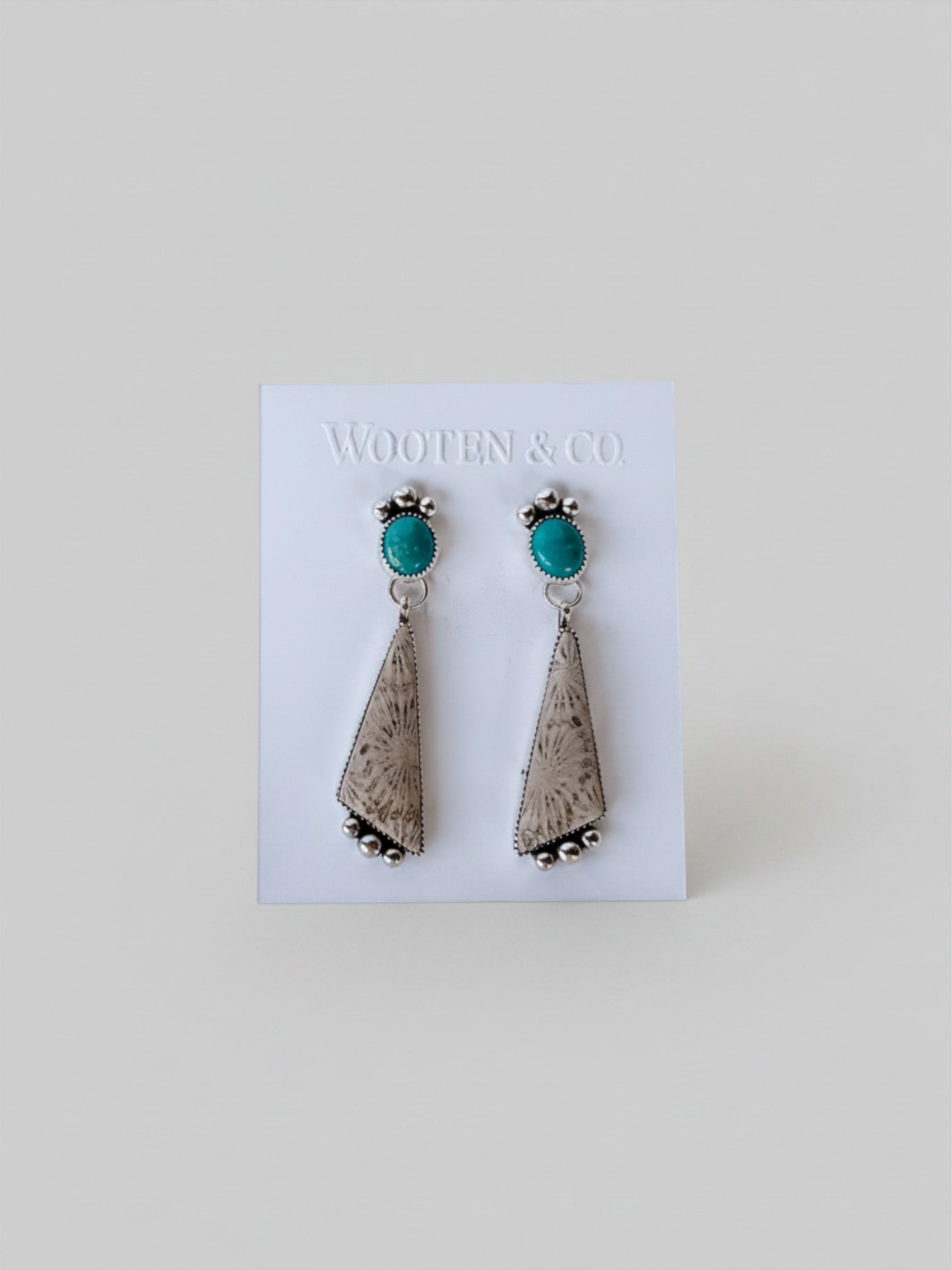 Wooten & Co. sterling silver earrings featuring turquoise cabochons and triangular fossilized coral dangles.